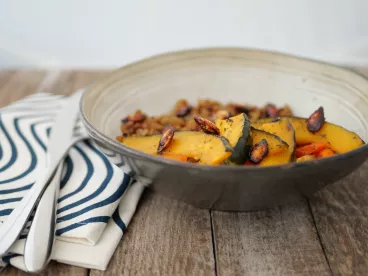 Plat végétarien préparé par Ansamble, composé de tranches de courge rôtie et d'un accompagnement de céréales, illustrant l'engagement de la société envers une cuisine saine et équilibrée.