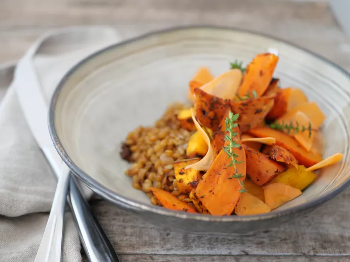 Plat végétarien préparé par Ansamble, composé de tranches de courge rôtie et d'un accompagnement de céréales, illustrant l'engagement de la société envers une cuisine saine et équilibrée.
